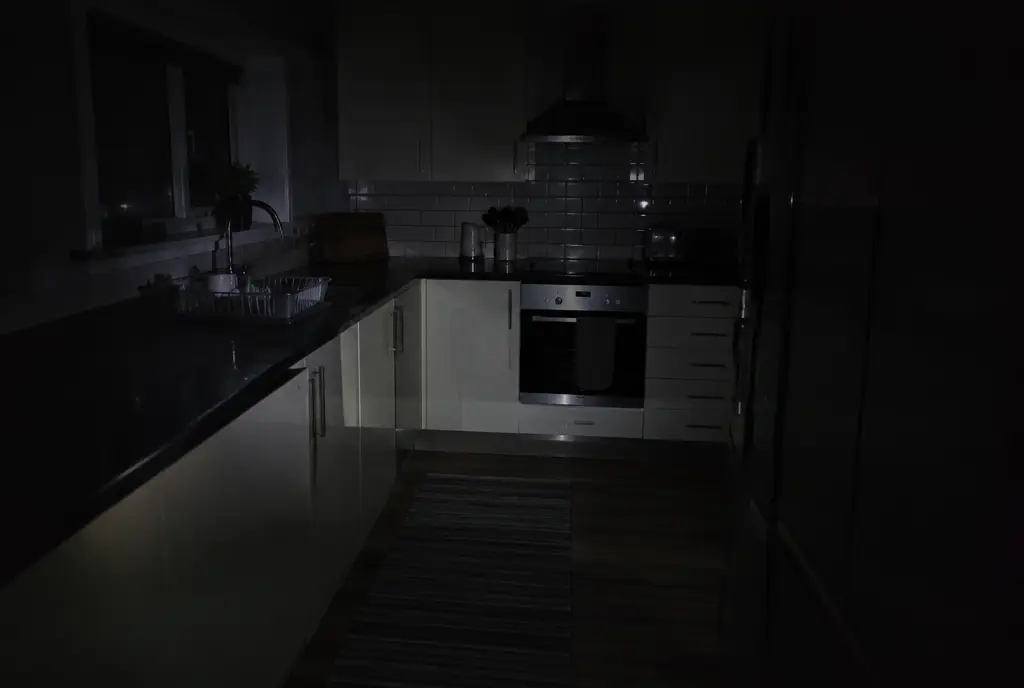 Dark kitchen during a power cut lit by a phone torch